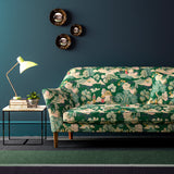 Sofa covered in a printed velvet fabric featuring a Japanese-style toile in green.