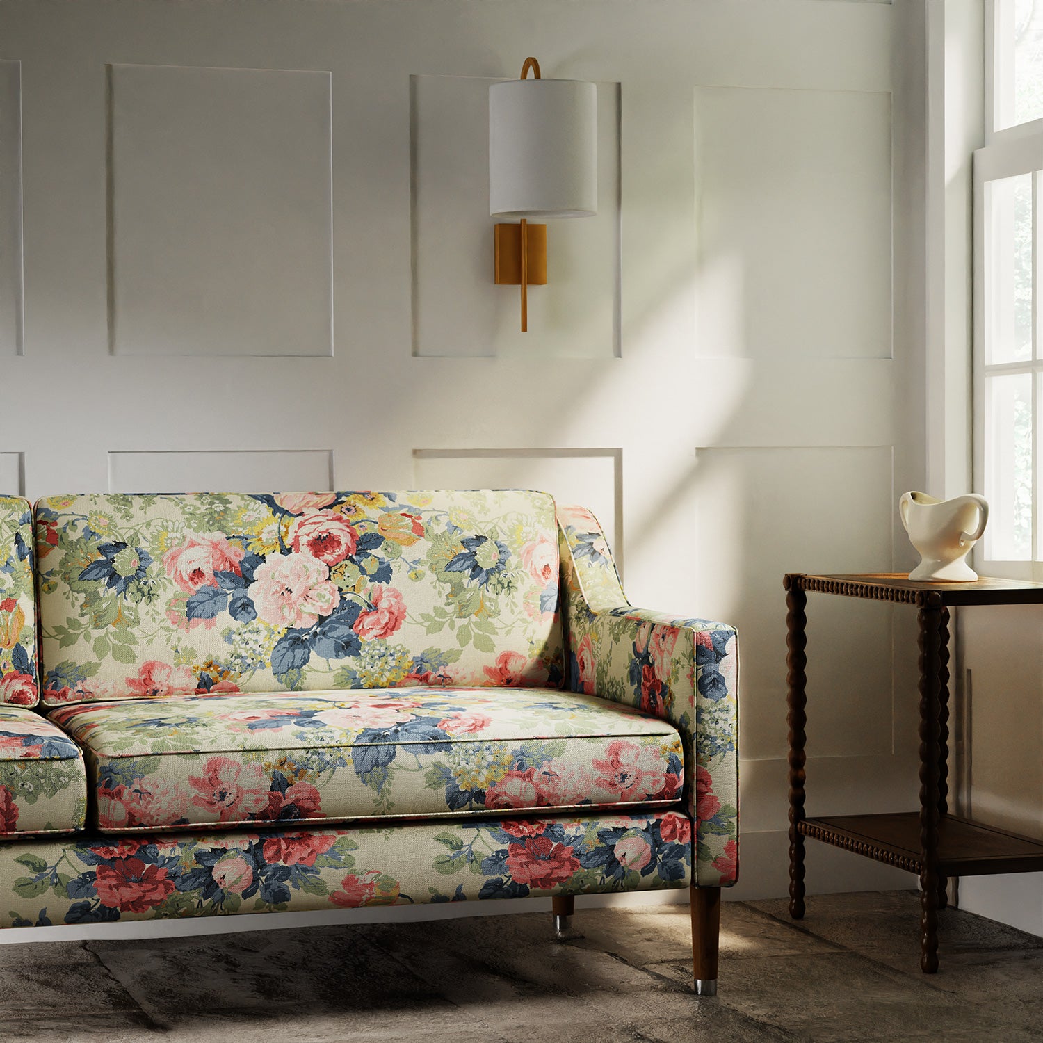 Sofa covered in a printed linen fabric showcasing bouquets of roses in gentle pinks and reds.