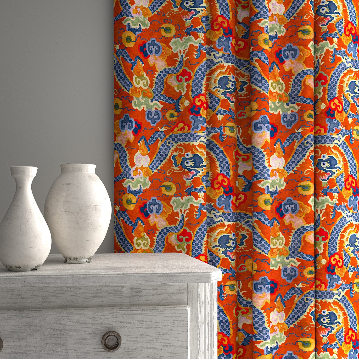 Velvet curtains upholstered in a printed velvet fabric with a intricate mirror dragon design in orange colours.