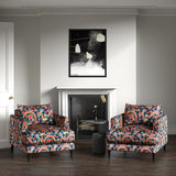 Velvet armchairs upholstered in a printed velvet fabric with a intricate mirror dragon design in blue and orange colours.