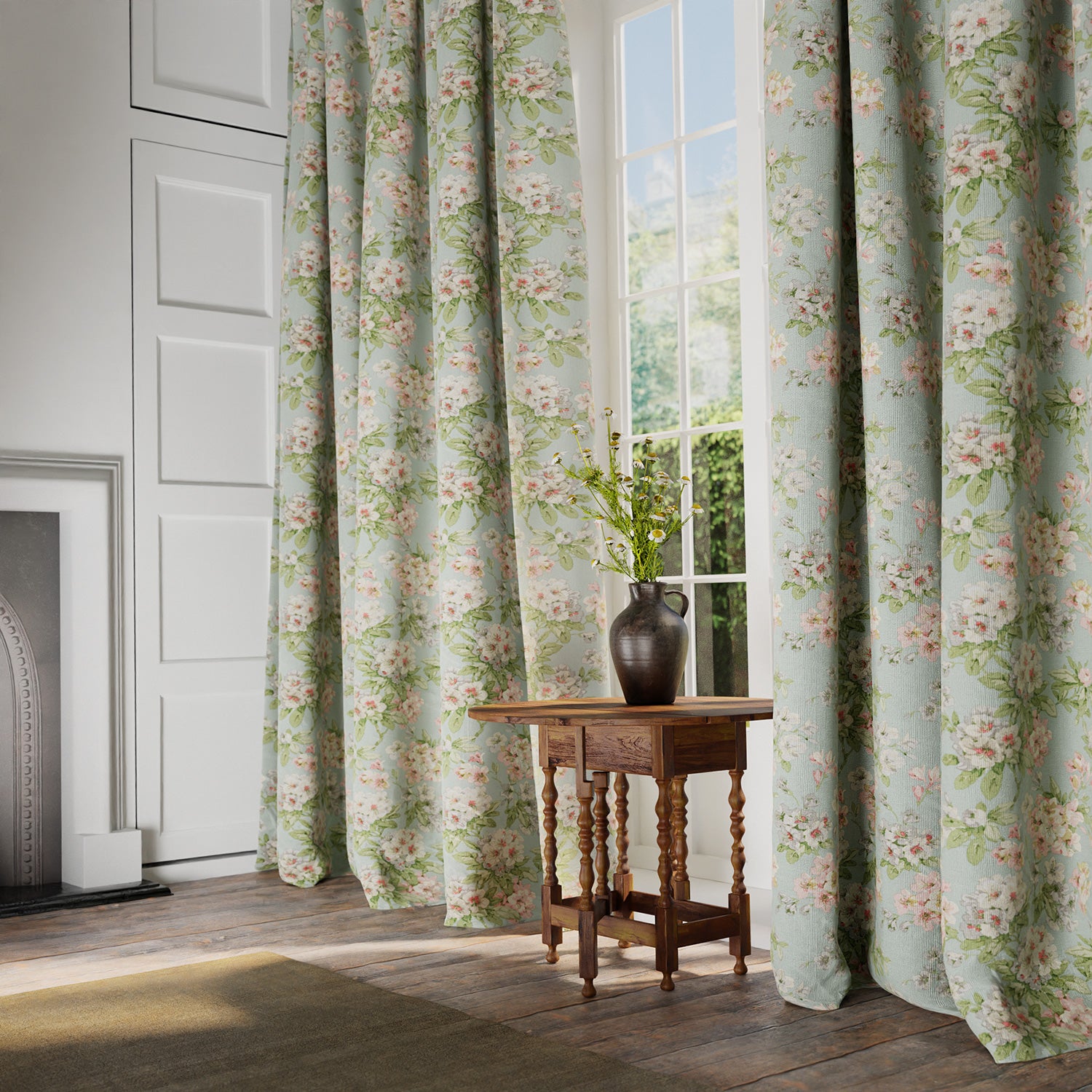 Curtains in a printed linen fabric with floral pattern in blue, green and white colours.