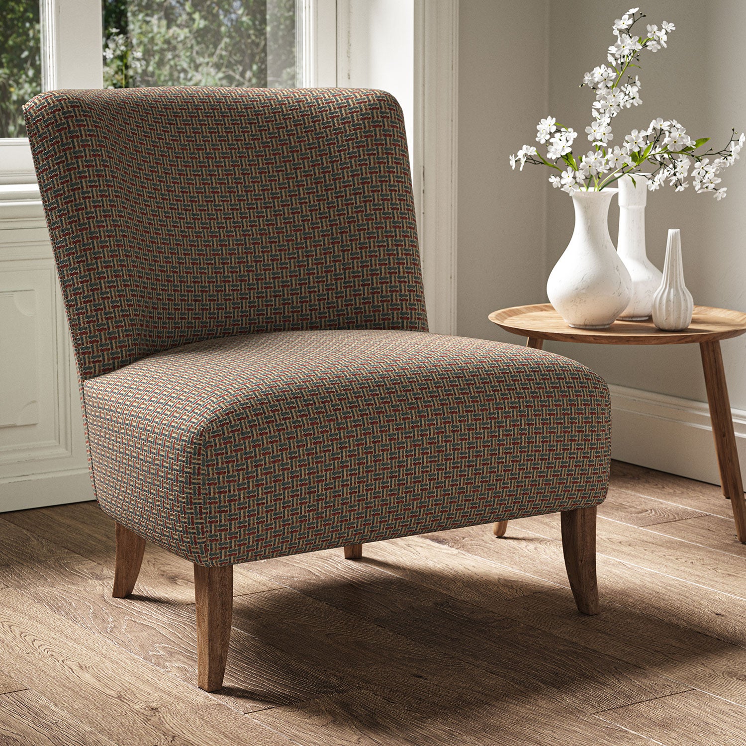 Armchair in a printed linen fabric with textural weave pattern in red, blue and yellow colours.