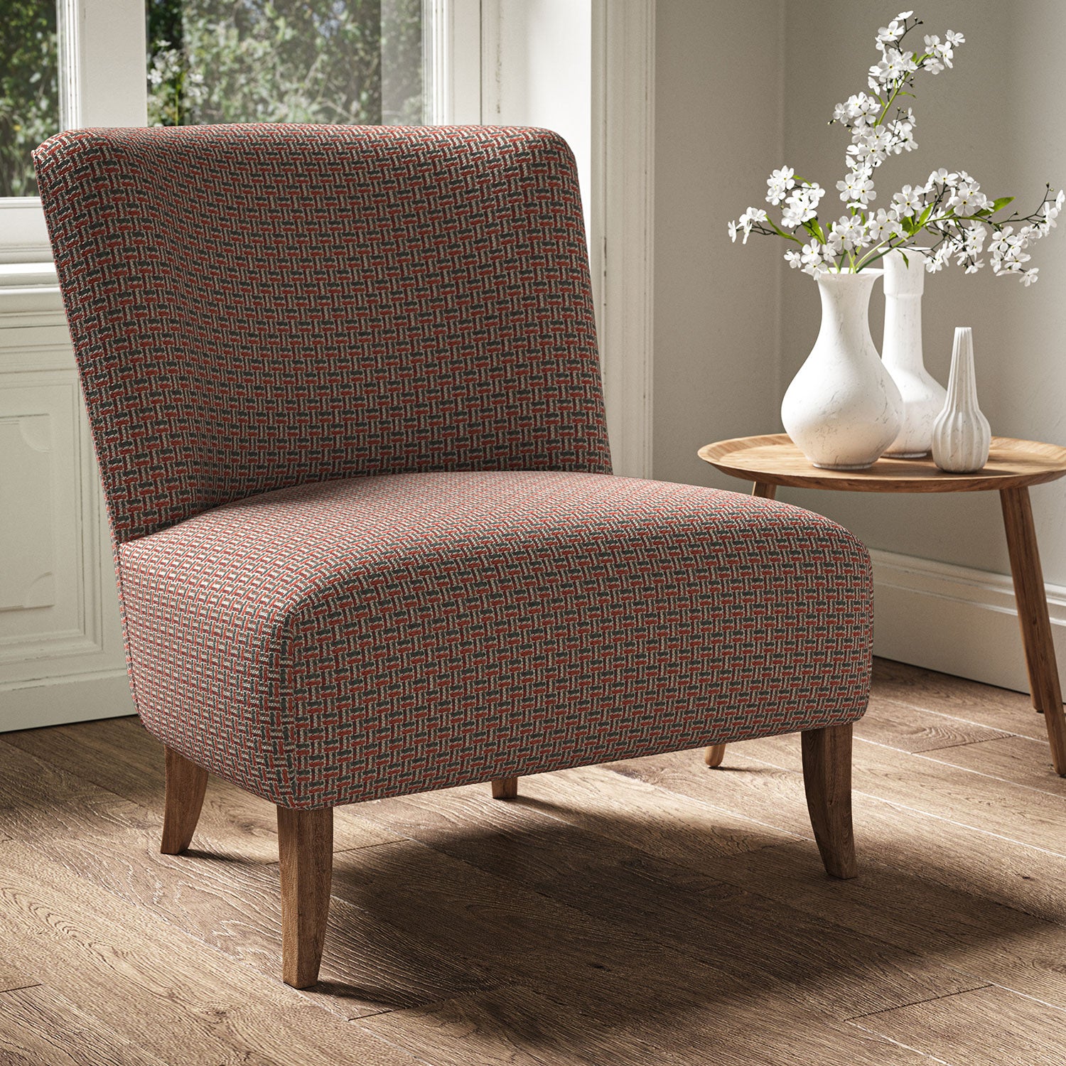 Armchair in a printed linen fabric with textural weave pattern in red colours.