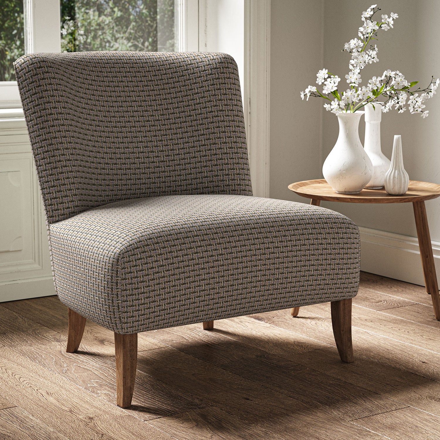 Armchair in a printed linen fabric with textural weave pattern in green and pink colours.