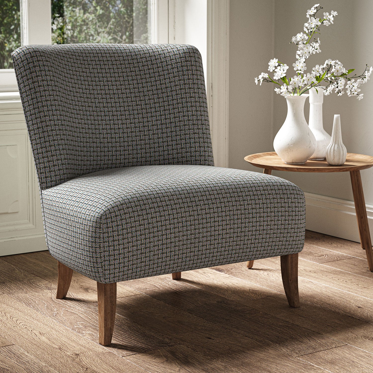Armchair in a printed linen fabric with textural weave pattern in brown, pink and blue colours.
