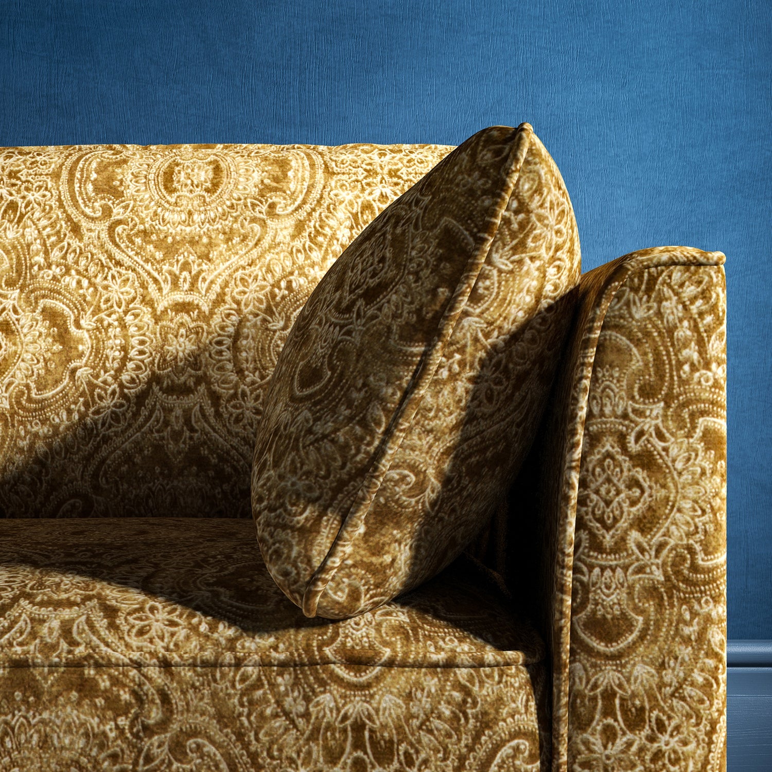 Sofa upholstered in a gold upholstery fabric with intricate jewel like design
