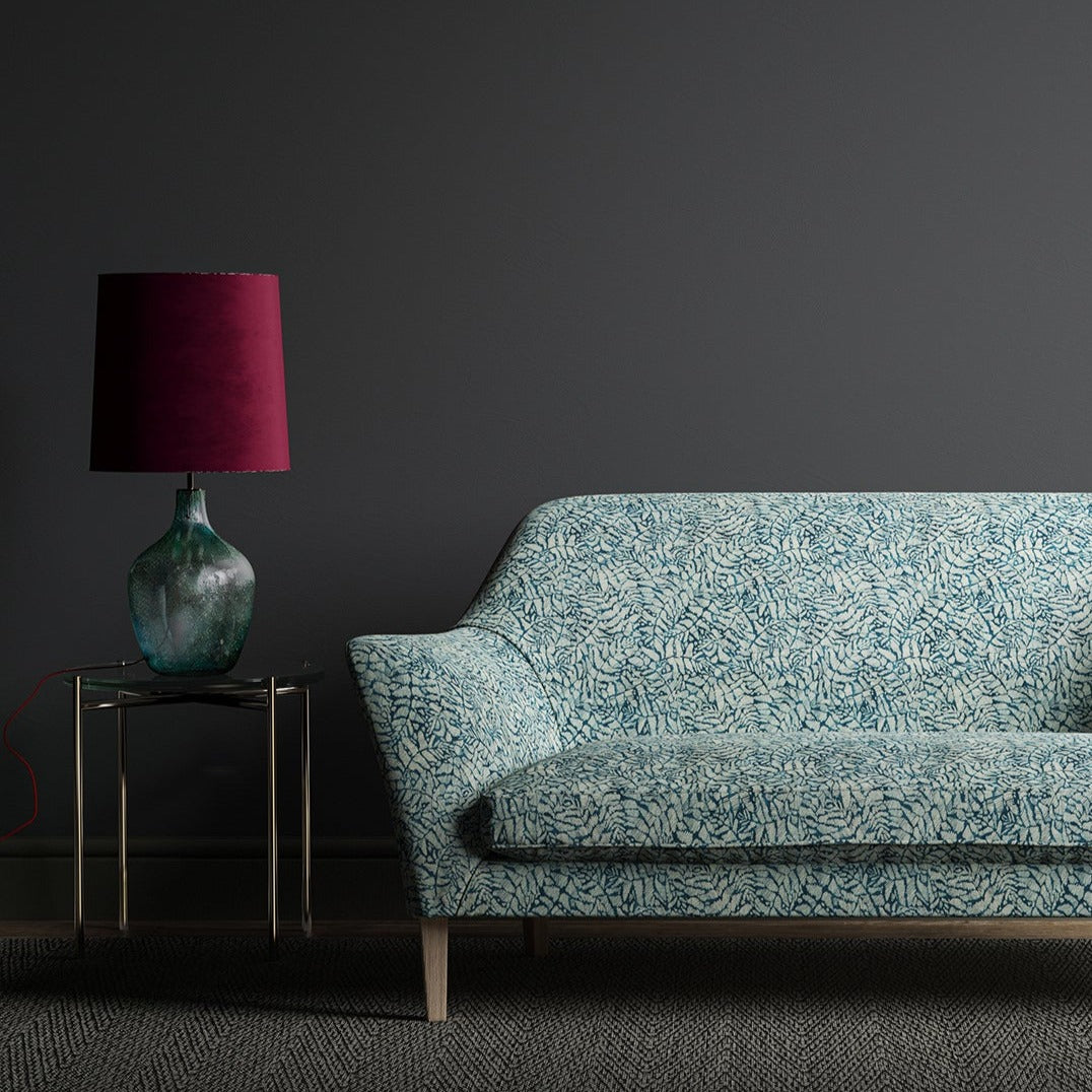 Sofa upholstered in a dark blue fabric with a small white print