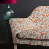Orange and grey sofa in upholstered in a fabric with a tropical leaf design