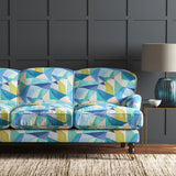 Velvet sofa upholstered in a velvet stain resistant fabric with a blue geometric design