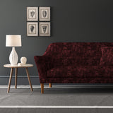 Velvet sofa upholstered in a dark red velvet fabric with a carpet design and a stain resistant finish