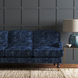 Blue velvet sofa upholstered in a blue velvet fabric with a carpet design and a stain resistant finish