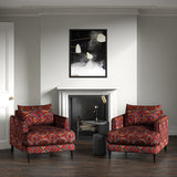 Armchairs in printed velvet fabric – an exuberant carpet design in red colours.