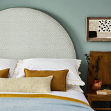 Printed linen fabric – a classic trellis design in blue, yellow, and cream – on a headboard