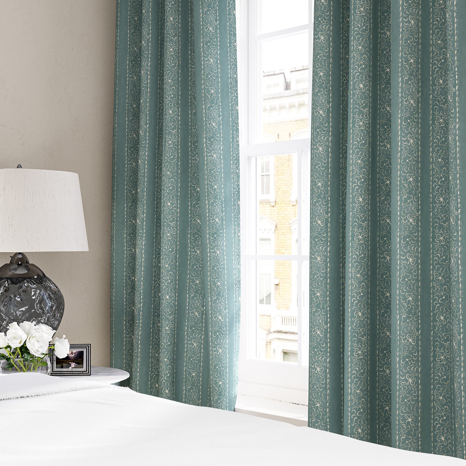 Linen curtains with a delicate pattern of moons and star-like dots in blue and cream