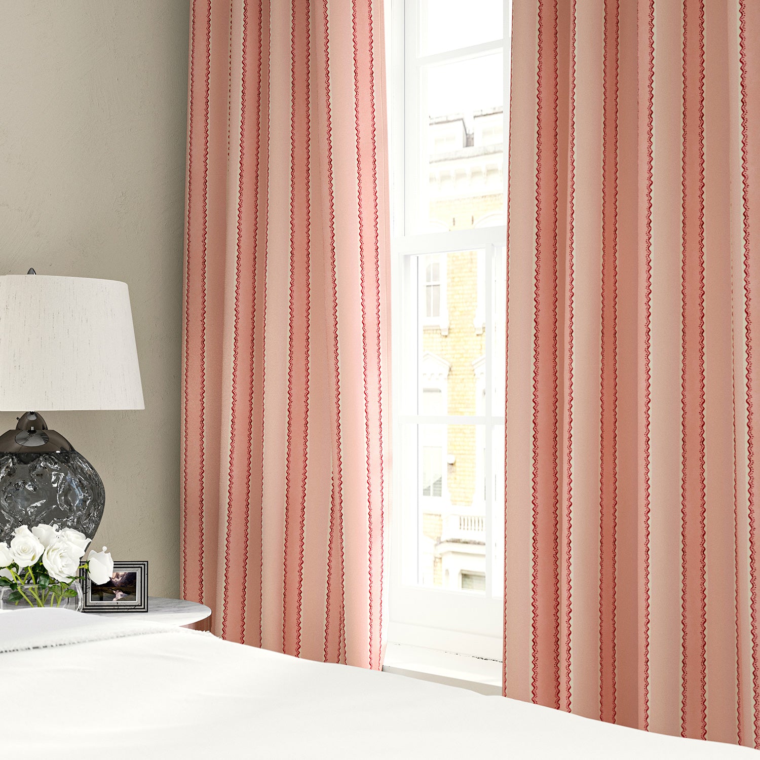 Linen curtains with a bold blocks of colour in this inviting stripe are softened with a painterly finish in pink, red and white