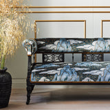 Velvet sofa upholstered in a printed velvet fabric with a scenic landscape design in blue colours.