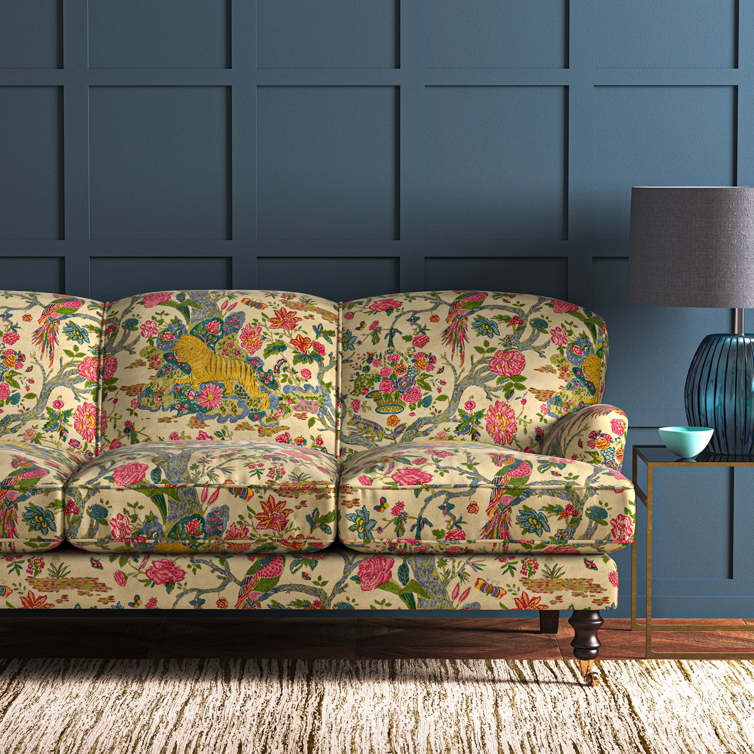 A printed velvet fabric depicts a menagerie of parrots, lions, and alluring flowers in cream on an sofa
