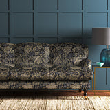 A printed velvet fabric showcasing an archival document, circa 1700s, this stylised floral is lavish, graceful, and timeless in blue on a sofa