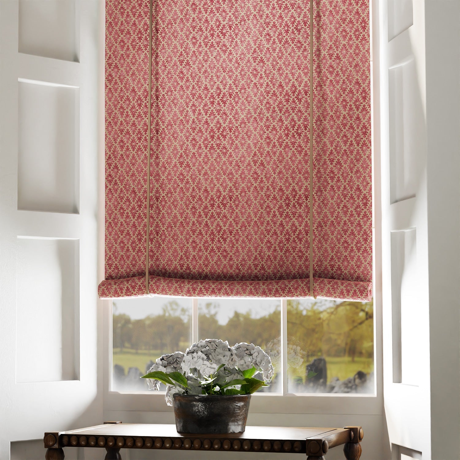Blind in a red and neutral printed linen fabric with a geometric pattern