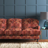 Sofa covered in a terracotta printed velvet fabric based on a classic Persian rug design.