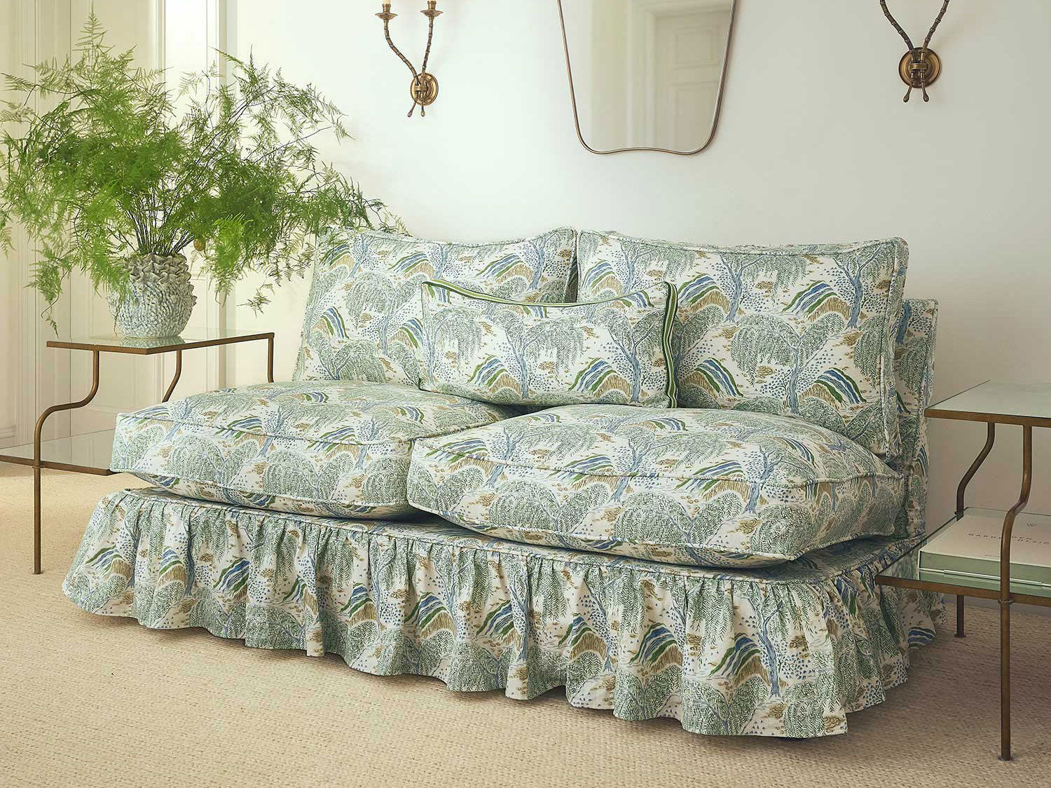 Traditional sofa upholstered in Linwood's Gwendolyn Emerald printed linen with botanical design, styled in a neutral living room with wall sconces, mirror, and lush greenery