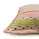 Decorative pink cushion with colourful striped pattern.