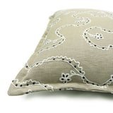 Decorative cushion with a free-flowing floral pattern on a sand coloured background.