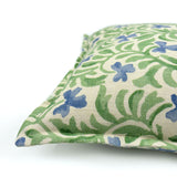 Decorative cushion with a green and blue floral pattern.