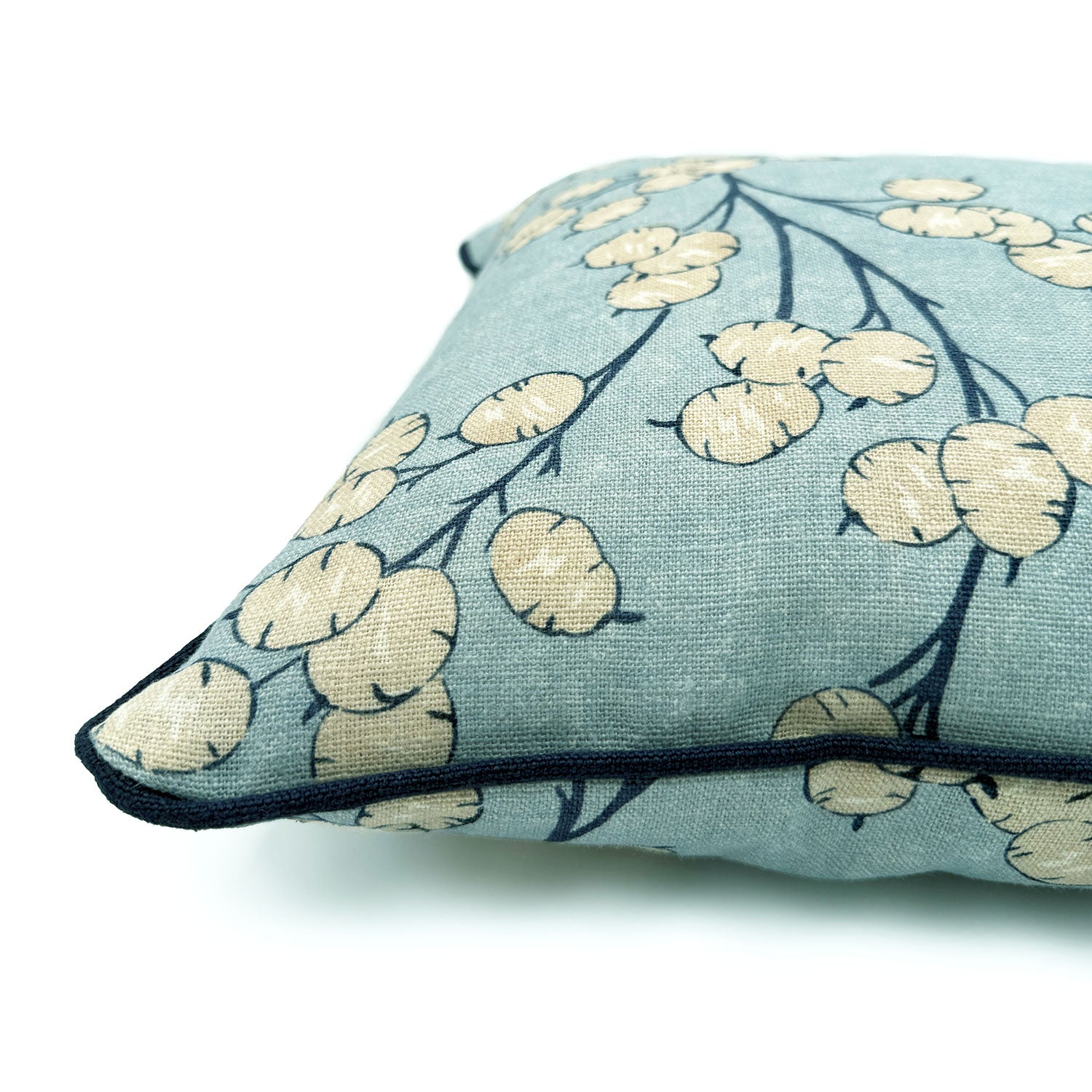 Close-up side view of Linwood cushion in Lottie, Sky showing fabric texture and piping in a strong dark blue linen.