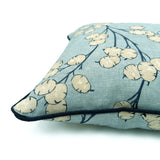 Close-up side view of Linwood cushion in Lottie, Sky showing fabric texture and piping in a strong dark blue linen.