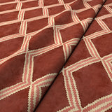 Close-up of red and pink printed velvet fabric featuring an irregular diamond motif with a soft, luxurious pile. 