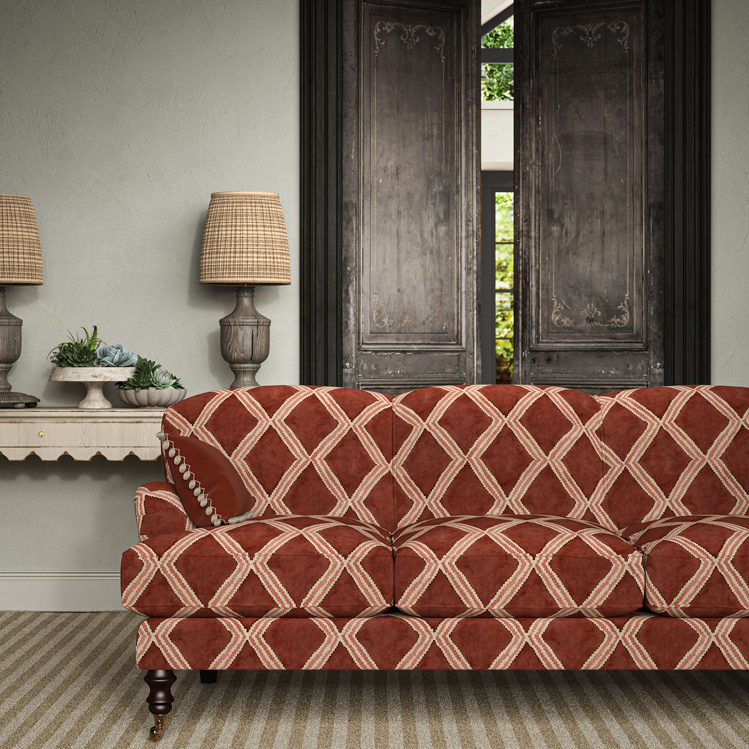 Sofa upholstered in red and pink printed velvet featuring an irregular diamond motif, styled in a timeless living room.