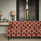 Sofa upholstered in red and pink printed velvet featuring an irregular diamond motif, styled in a timeless living room.