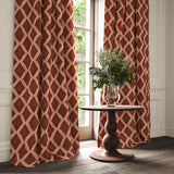 Red and pink printed velvet curtains with an irregular diamond pattern framing a tall window.