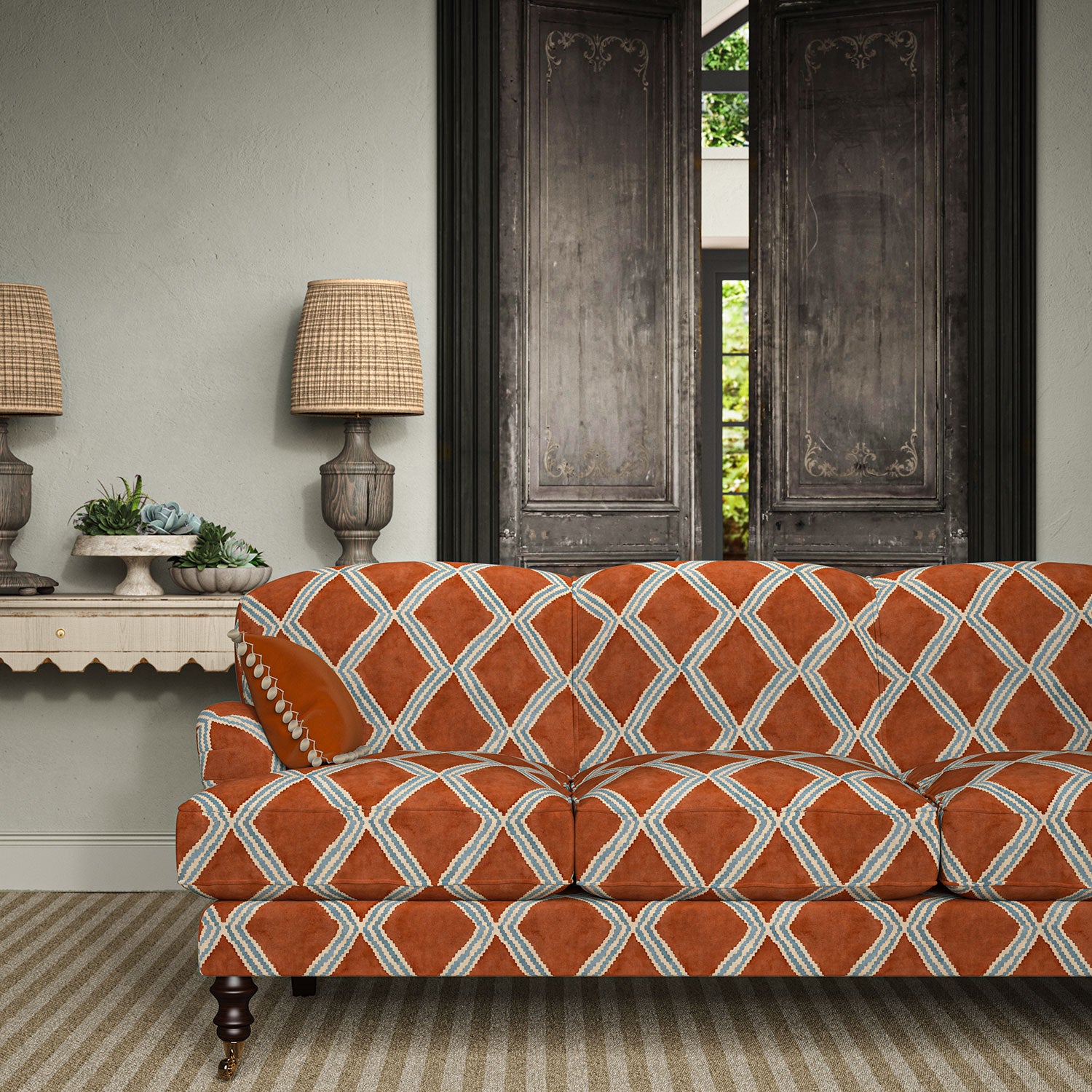 Sofa upholstered in red and blue printed velvet featuring an irregular diamond motif, styled in a timeless living room.