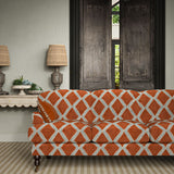 Sofa upholstered in red and blue printed velvet featuring an irregular diamond motif, styled in a timeless living room.