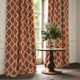 Red and blue printed velvet curtains with an irregular diamond pattern framing a tall window.