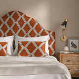 Bedroom with a curved upholstered headboard covered in red and blue printed velvet featuring an irregular diamond motif.