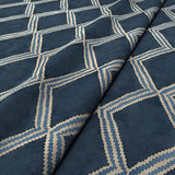 Close-up of blue printed velvet fabric featuring an irregular diamond motif with a soft, luxurious pile. 