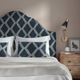 Bedroom with a curved upholstered headboard covered in blue printed velvet featuring an irregular diamond motif.