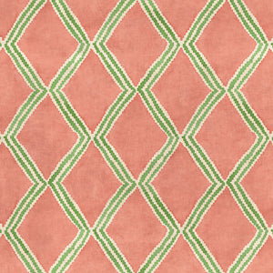 Close-up of orange and green printed velvet fabric featuring an irregular diamond motif with a soft, luxurious pile. 