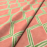 Close-up of orange and green printed velvet fabric featuring an irregular diamond motif with a soft, luxurious pile. 