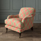 Accent chair upholstered in orange and green printed velvet with an irregular diamond pattern, showcasing the fabric’s rich texture. 