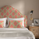 Bedroom with a curved upholstered headboard covered in orange and green printed velvet featuring an irregular diamond motif.