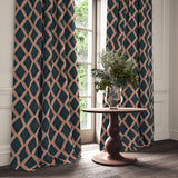 Blue and red printed velvet curtains with an irregular diamond pattern framing a tall window.