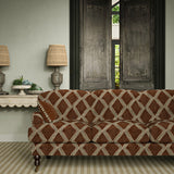 Sofa upholstered in brown and blue printed velvet featuring an irregular diamond motif, styled in a timeless living room.