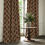 Brown and blue printed velvet curtains with an irregular diamond pattern framing a tall window.