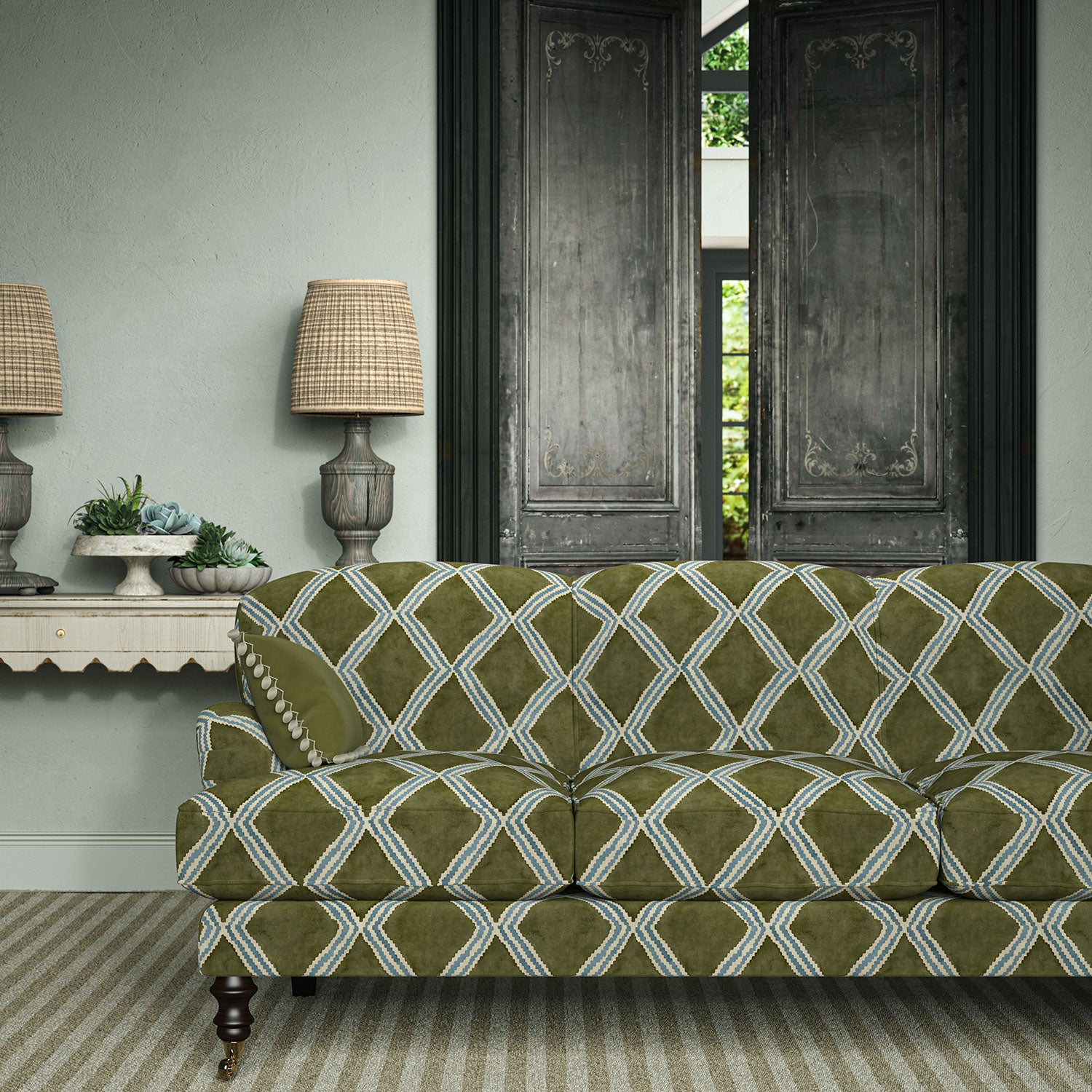 Sofa upholstered in green and blue printed velvet featuring an irregular diamond motif, styled in a timeless living room.