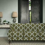 Sofa upholstered in green and blue printed velvet featuring an irregular diamond motif, styled in a timeless living room.