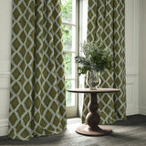 Green and blue printed velvet curtains with an irregular diamond pattern framing a tall window.